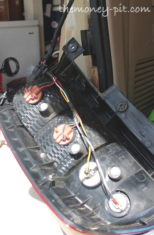 The tail light housing should fall right off. The backside of it will