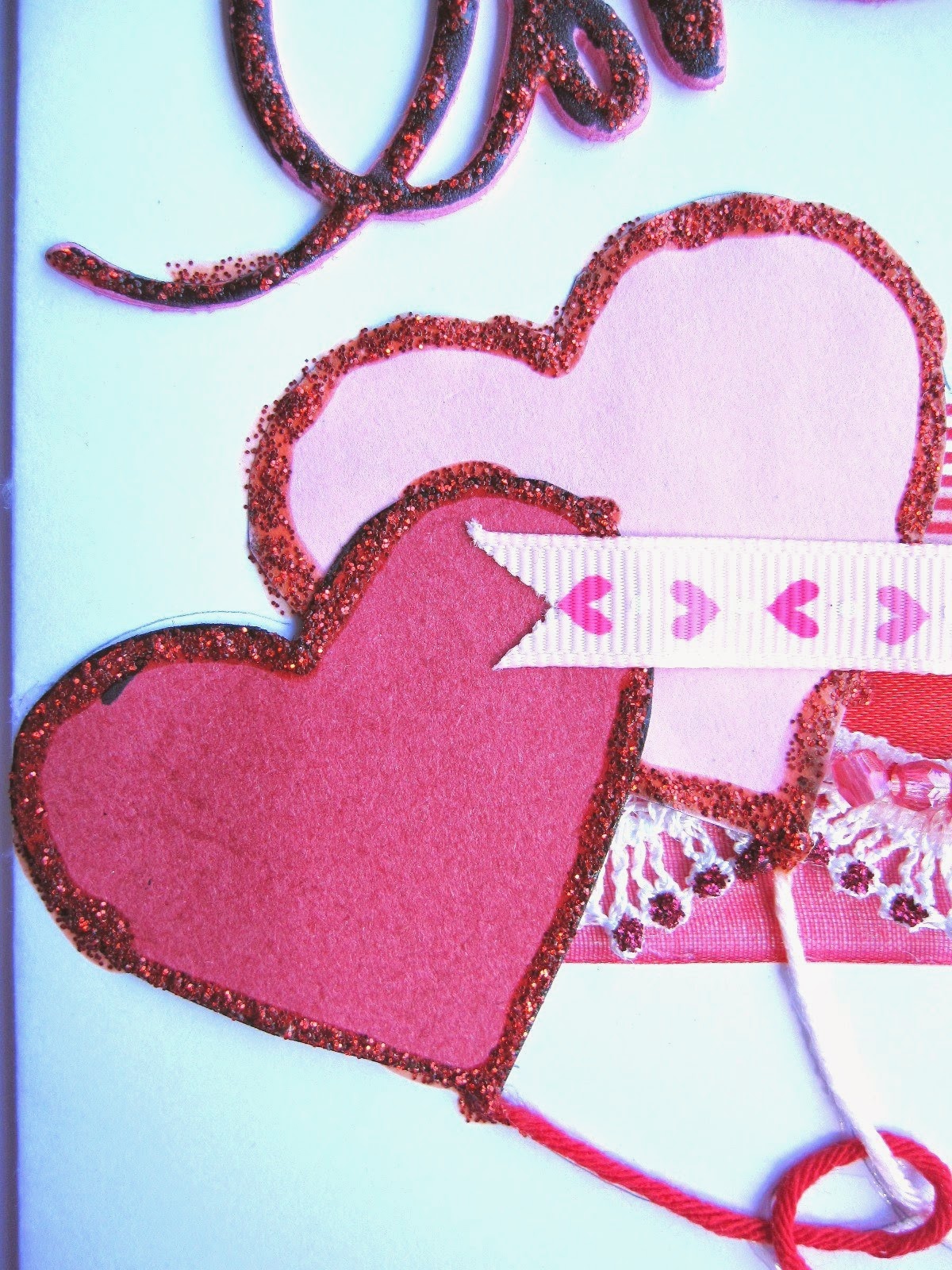 detalle tarjeta scrapbooking San Valentín con dos corazones con forma de globo rojo y rosa con borde de stickles cramberry