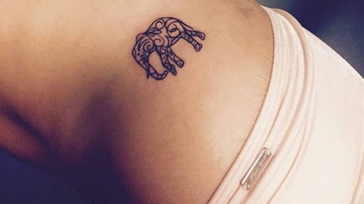 Um elefante é estilizado com uma ornamentada padrão em preto tatuagem.