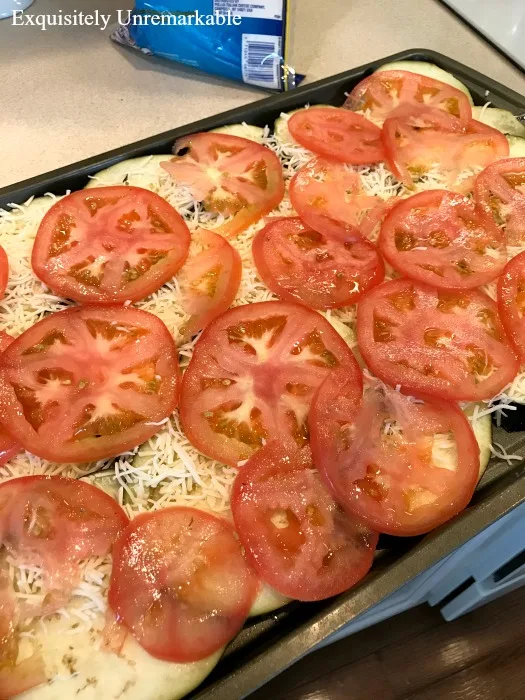 Eggplant Pizziola with tomatoes and shredded cheese on a metal cooking tray