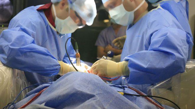 طبيب جراح يغط بالنوم ممسكا بيد مريض! بعد 6 عمليات جراحية متتالية.صورة