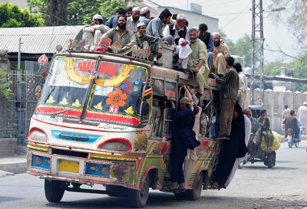 Superlotação de ônibus no Paquistão, mais de 15 pessoas são transportadas sobre o teto do veículo