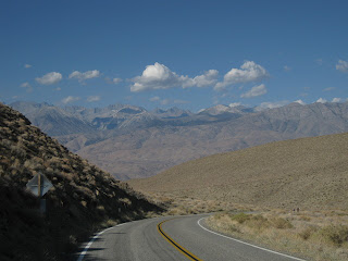 Two cyclists climbing through the desert landscape along California State Route 168 near Big Pine, California