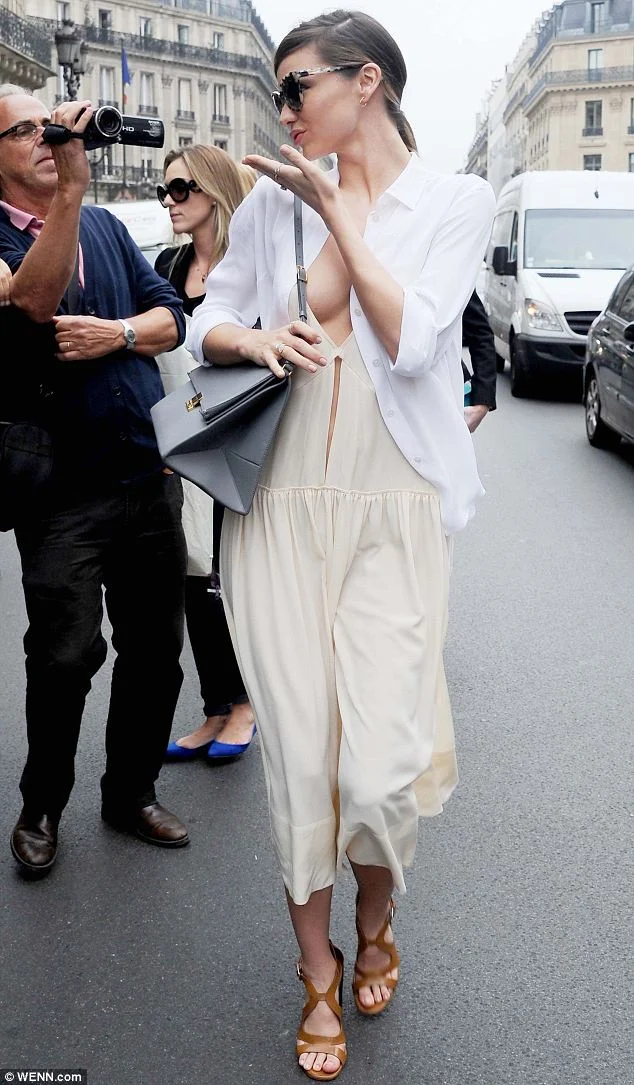 Miranda Kerr shows off cleavage in a white dress at the Paris Fashion Week