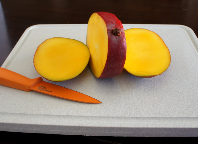 A sliced mango on a cutting board