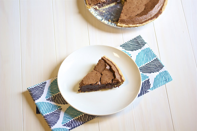 overhead shot of chocolate pie on a white plate and blue napkin