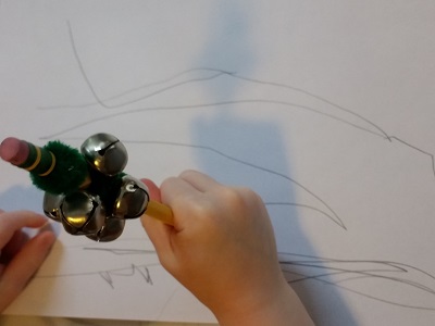Preschooler drawing with pencil & bells