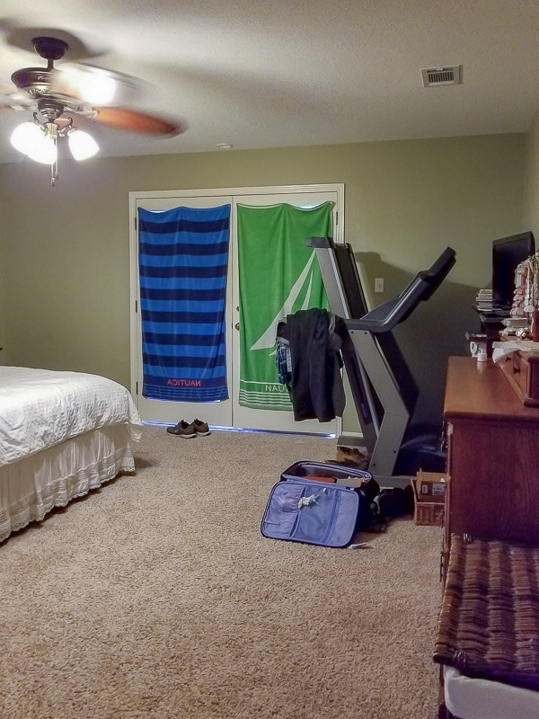 clutter, dark walls, towels hanging on french doors to block light