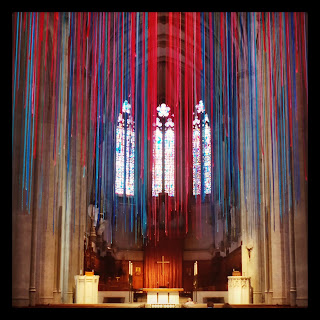 Thousands of different-coloured lengths of ribbon, hanging from the ceiling, facing the altar