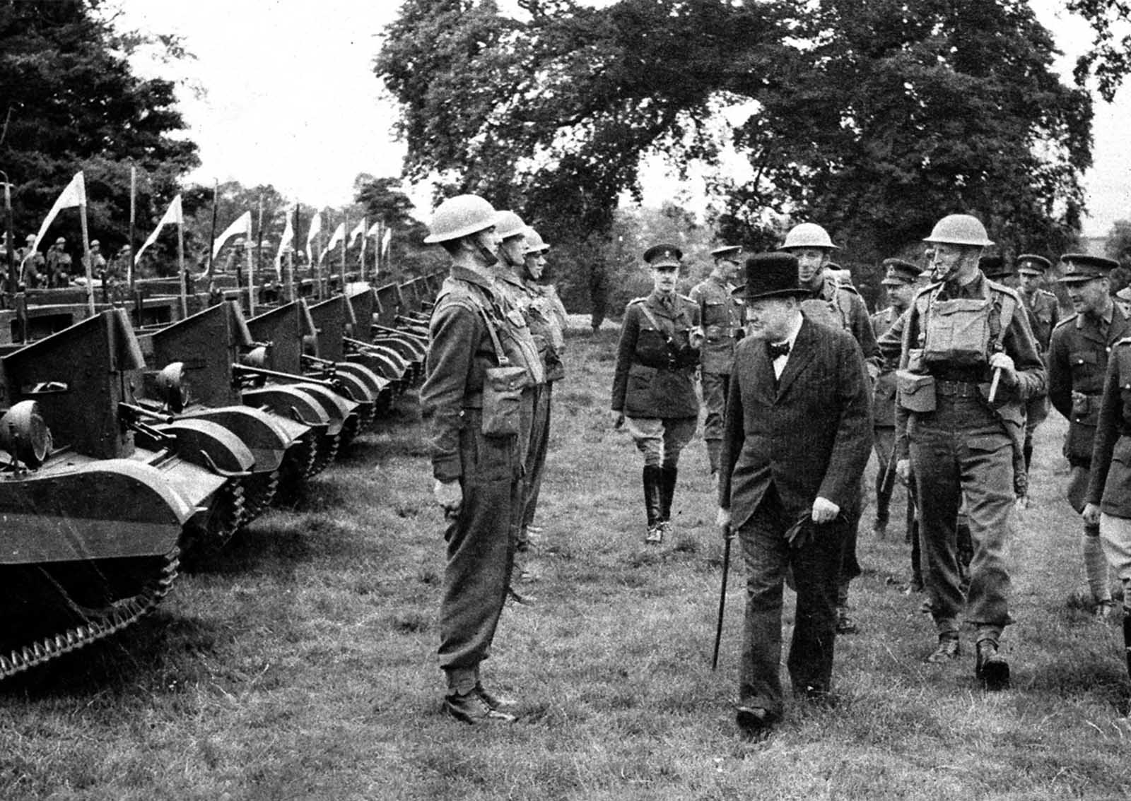 British Prime Minister Winston Churchill inspects Britain's Grenadier guards standing at attention in front of Light Bren gun armored units in July, 1940.