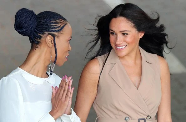 Meghan Markle wore a new double breasted trench dress by Banana Republic and legend suede pumps by Stuart Weitzman