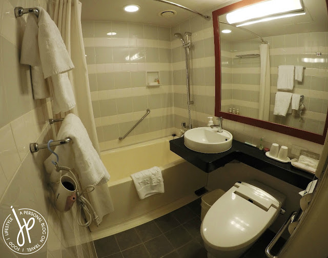 hotel bathroom with toilet, sink, shower, and bathtub