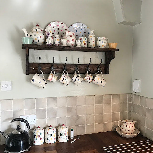 cottage kitchen inspiration featuring log filled fireplace and Emma Bridgewater collection 
