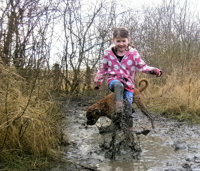 girl splashing in puddle mud water dirt