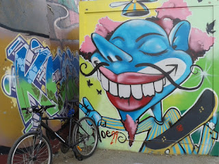 graffiti colorido con expresión de una gran sonrisa bicicleta y patinete