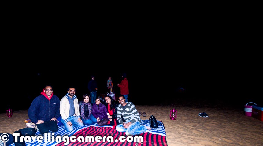 While in Rajasthan and around desert area, it's a must do thing to visit these Deserts & explore a very different type of experience. The Excitement level increases if we plan to have bonfire in the desert under star studded sky. This time 'Malji Ka Kamra' team organized bonfire for us in Desert of Churu. It was one of the most exciting part of our weekend trip to Churu. This Photo Journey shares some of the photographs shot in the desert during Bonfire and some incidents we came across.Many times I planned weekend trips to Rajasthan from Delhi but this was first time when we were in an area surrounded by Deserts. So this weekend trip was quite special for us. During the trip we were staying at 'Malji Ka Kamara' and they arranged this bonfire for us in Desert. The very first experience was driving on Desert and the way SUVs were slipping on sand. We started in 3 cars from Haveli and on the way everyone fit into the SUVs we had. We went ahead on these SUVs as normal cars can't be driven on sand.Whole Gang of Writers and Bloggers was excited to have fun in Desert. All arrangements were already done before we hit the Desert for Bonfire. When we reached, we had to climb up to reach the main place, where lighting & seating arrangements were done. Chef was ready with some Scrumptious snacks. While we were settling there, few folks started setting up the cameras on tripods to shoot stars, star-trails and desert lit with moonlight. Few of us were very focused to keep track of shooting stars.Desert Bonfires in Rajasthan are very popular during the month of December. Many of the tourists hit Rajasthan to celebrate Christmas and New Year in Desert camps. Desert Bonfire on Christmas eve sounds very exciting. And this is what comes to my mind when I think about this - Jingles on Guitar, Cake with Wine and gifts for each other. Bonfire in Desert can bring lot of excitement and craziness. On the same lines, New Year Eve in Desert around bonfire can be very special with friends and family. With time, cost of celebrations of New Year have increased a lot i cities and a Desert Bonfire with friends can be a brilliant option with much lesser cost and a private affair.The sad part of the bonfire was unavailability of drinks in Desert. Malji Team had only beer to offer and many of us couldn't have anything else. I opted for beer and found it very different. I never had such strong beer before. Hope that other guests at Malji Ka Kamara ensure that they arrange drinks themselves or request the team to arrange variety of stuff while in desert. We would have loved to have some options in drinks to enjoy the Desert bonfire better with star studded sky and very frequent shooting stars.Suddenly everyone started noticing the silence of desert and the discussion lead to ghost stories. Now ladies wanted to act like ghosts in the desert. At least they wanted to have some posed photographs in desert by giving some evil impressions. Priyanka lead this shoot and everyone else joined the gang. This was the time, when I got up from my seat and started clicking photographs of these folks. Before that I was feeling lazy and enjoying the beer at Desert Bonfire. Are these stars in above photograph? What do you think?It was time when people wanted there special photographs. It was a real challenge for me because of very low light and didn't want to use flash. So above photograph tells about the process we followed to click various photographs you see in this Photo JourneyBefore visiting Churu, whenever I heard of 'Desert Bonfire', it was mostly about Jaisalmer or Jodhpur in Rajasthan state of India or Saudi. Few of my friends had great time in Jaisalmer, when they stayed in sand dunes and spent most of their time around Deserts only. Hopefully I will plan a trip to Jaisalmer soon.It was an amazing experience of bonfire in Desert. With time, it was getting very cold in the desert and we planned to move back to the Haveli (Malji Ka Kamara) at around 11:30pm. There were lot of things in our To-Do list for next day. We had dinner at the hotel and moved to our rooms to take rest and start the new day with a city tour of Ramgarh.