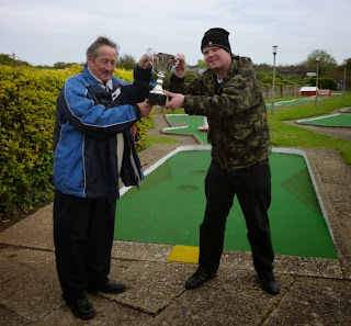 Brad receives the Skegness Minigolf Championship trophy from reigning Holiday on the Buses Butler Cup Champion Eric Huckle Brad receives the Skegness Minigolf Championship trophy from reigning Holiday on the Buses Butler Cup Champion Eric Huckle