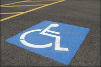 Photo of a disability parking space, focused on the painted wheelchair symbol and lines