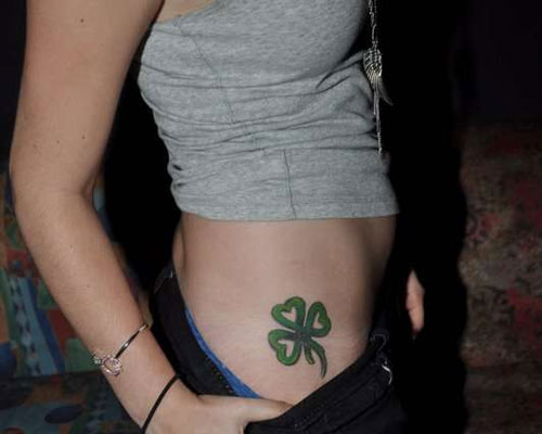 chica con tatuaje de trébol celta en la cadera