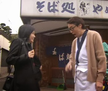 Misaki and Wakamura's father in front of the soba shop.