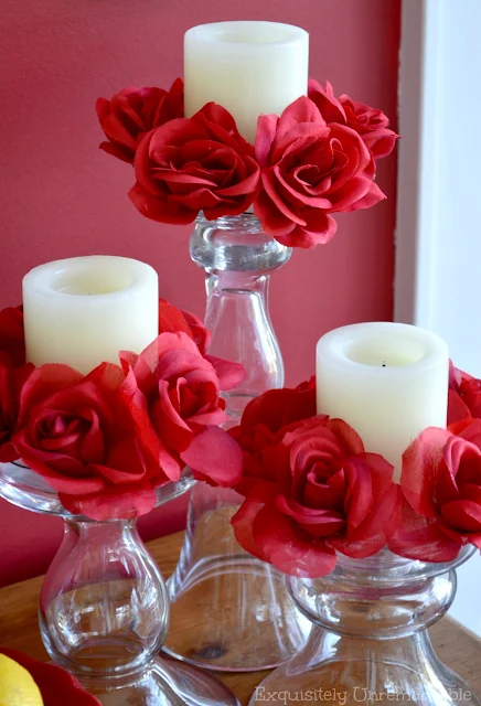 Red rose candle rings on white pillar candles