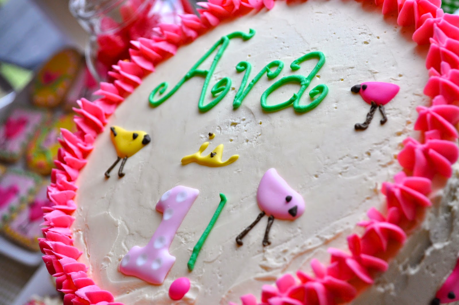close up of top of the cake with "Ava is 1" and little Penelope birds