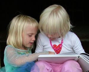 Sisters reading a book together - Stock Photo Credit: hortongrou