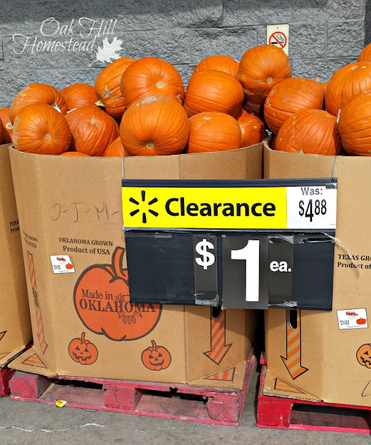 Two huge boxes of pumpkins for sale. A sign reads "Clearance: $1"