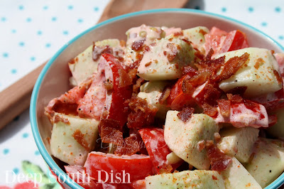 A lightly dressed tomato and cucumber salad tossed with a seasoned, mayonnaise-based dressing and lots of crumbled bacon!