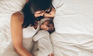 Woman cuddling with newborn baby
