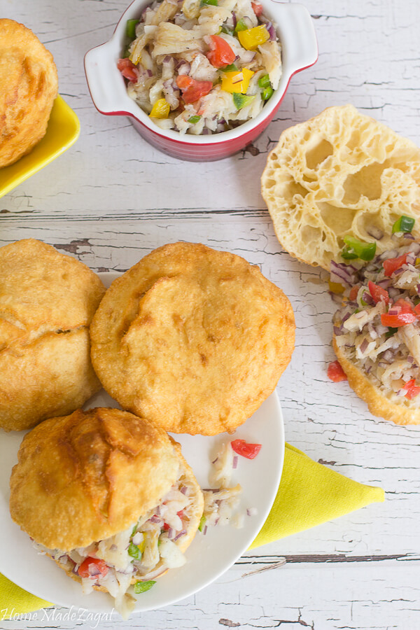 Three fried bakes with saltfish on a serving plate.