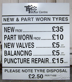 TT Motor Centre sign for new and part worn tyres with a price list new from £35, part worn form £10, new valves £5 per wheel, balancing £5 per wheel, puncture repair £15 each. Please note tyre disposal £2.50 per tyre. The design is black text with a white background, it is very clear and simple making it easy to read for customers.