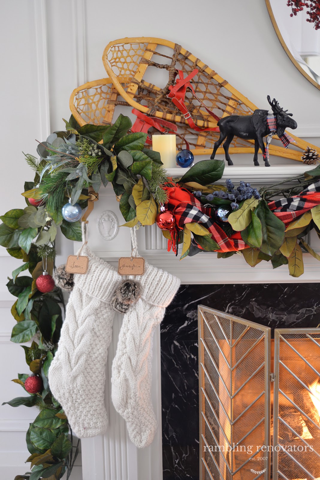 A lush and colourful red and blue Christmas mantel with a plaid scarf, blueberry picks and rustic accents