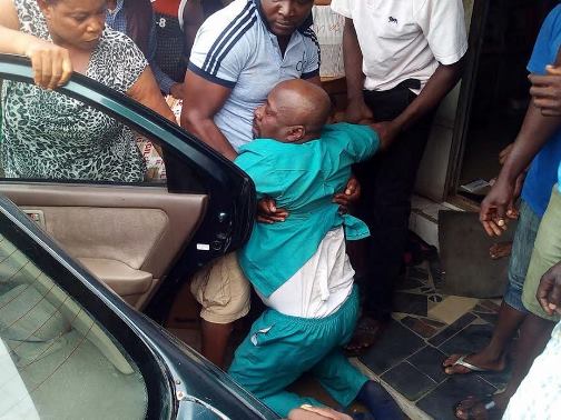 Photo: Lol! Man who slapped policeman's wife pretends to faint as he is being dragged into a car in Calabar