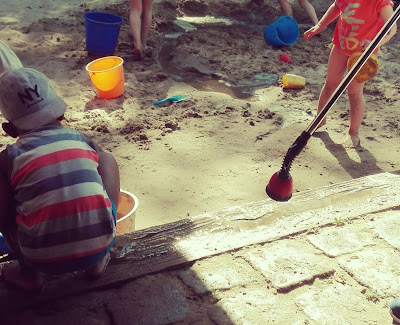 Spielende Kinder im nassen Spielplatzsand