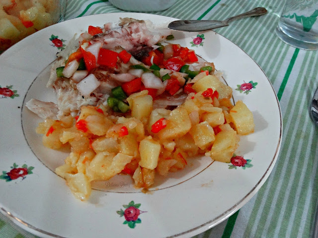Porción de pescado y papas con salsa criolla