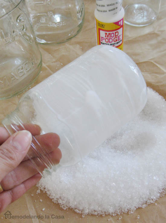 rolling clear glass jars with Modge Podge onto Epsom salts