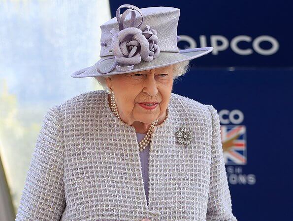 The Queen wore a pastel purple dress which featured a knee-length pleated skirt and a long quilted coat with three layers of pearls necklece