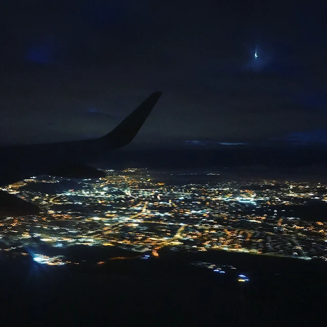 view from plane window at night with city light below