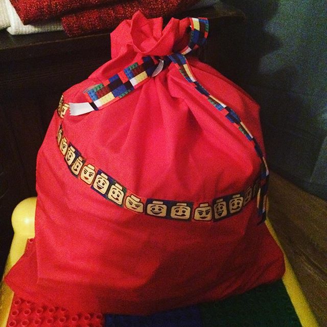 A homemade red sack with lego block ribbon and lego head pictures