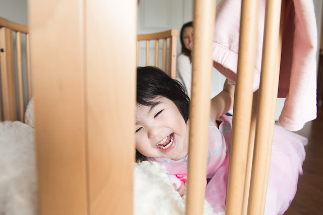 Photo of little girl laughing and playing in her room taken during family photo session in Ottawa Ontario by Melanie Mathieu Photography