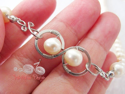 Close up of wire wrapped pearl infinity clasp