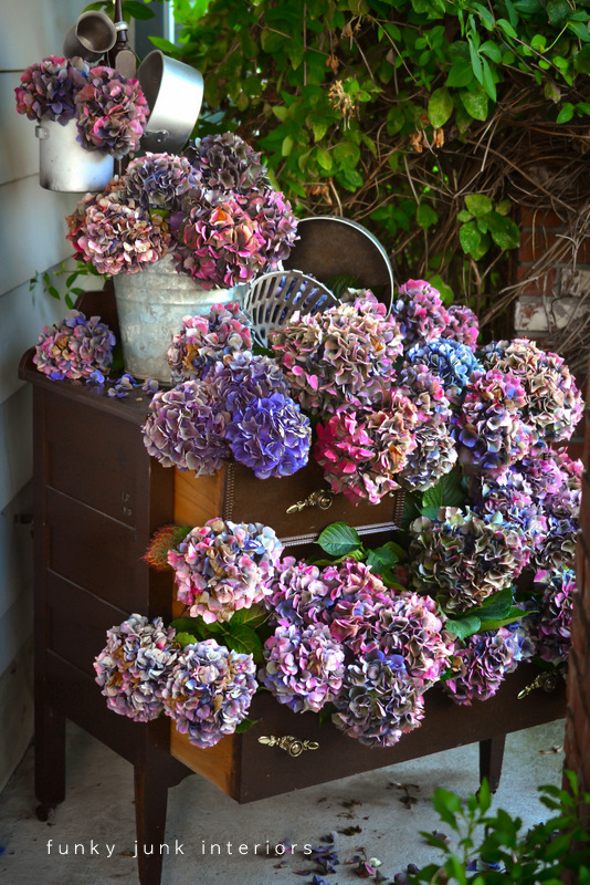 Múltiples colores hortensias secas en un aparador al aire libre a través de Interiores Funky Junk