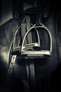 A Black leather saddle with silver stirrup leathers 