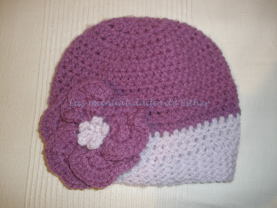 Gorro con lanas morada y lila realizado a crochet y adornado con un floripondio también a crochet
