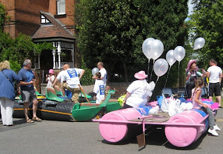 One green and one pink themed raft on the pavement waiting for their turn to launch