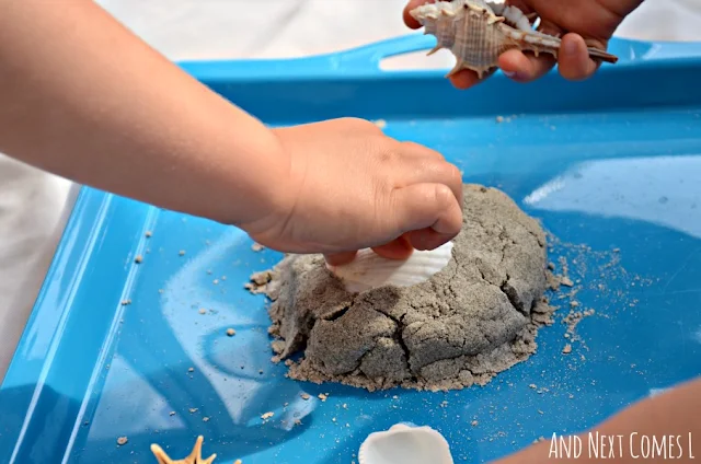 Stamping seashells into homemade sand dough