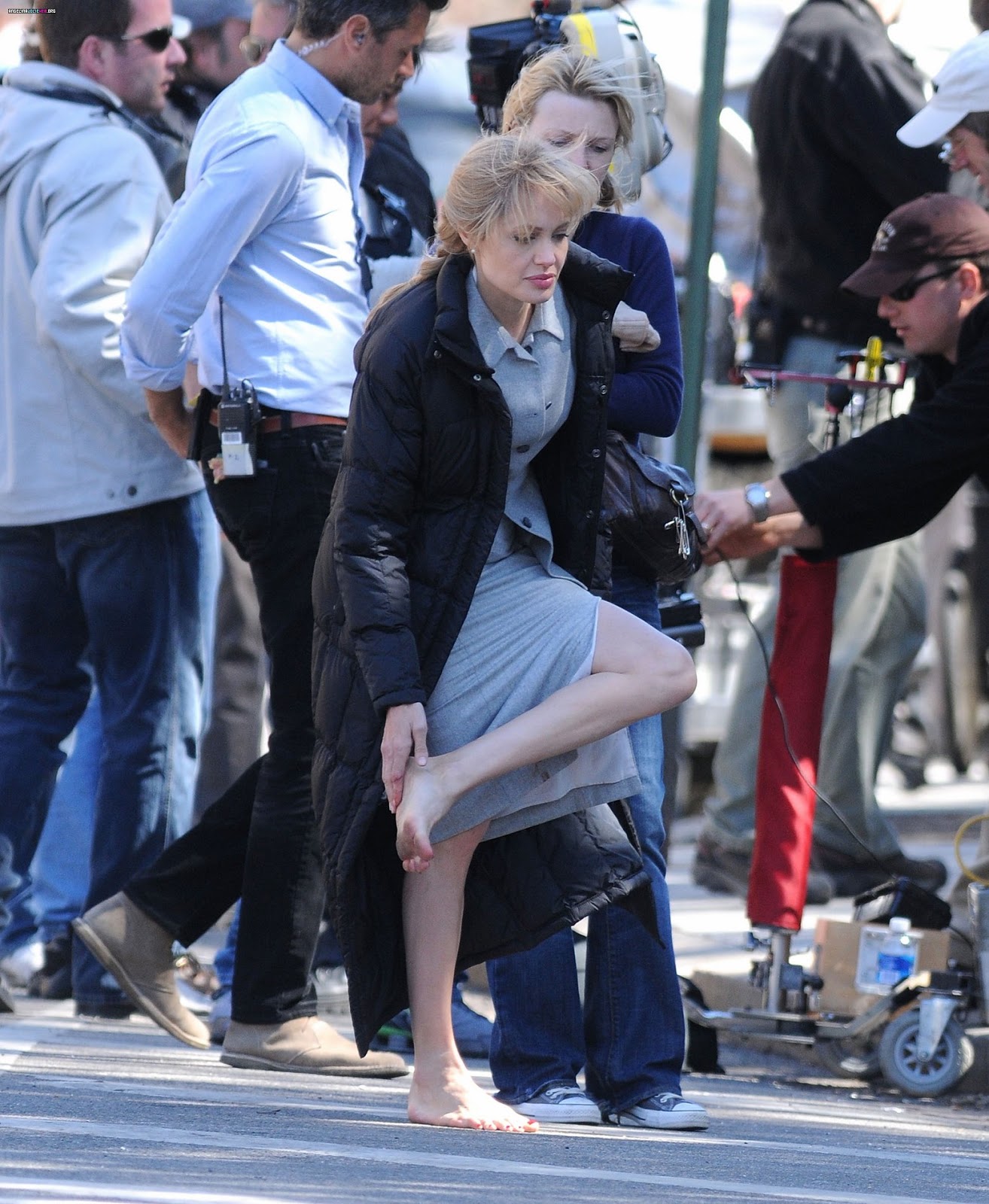 Angelina Jolie walking barefoot on the set of a movie.