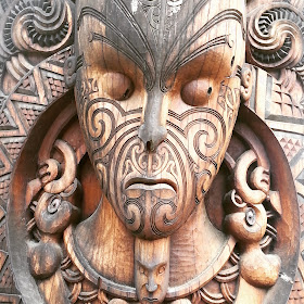 Close up of a maori carving of a face.