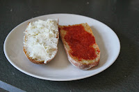 Vegetable demi-baguette, split and spread with goat cheese and tomato paste
